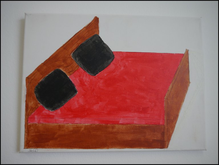 Bett aus Holz mit roter Decke und schwarzen Kissen