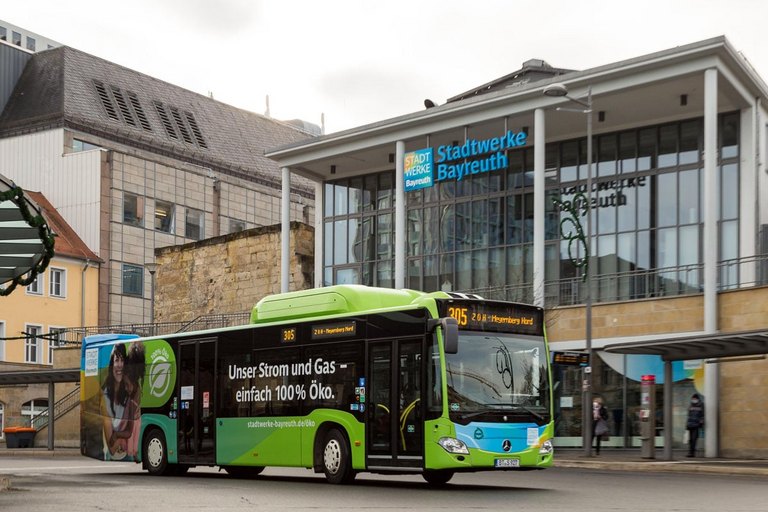 gruener Bus vor einem Gebaeude 