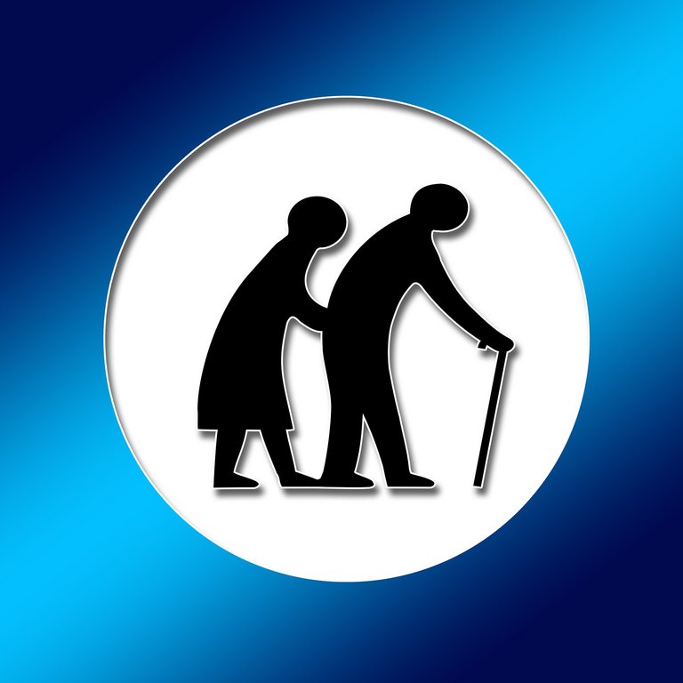 Zwei Senioren in gebückter Haltung, die gemeinsam gehen, der Mann am Stock