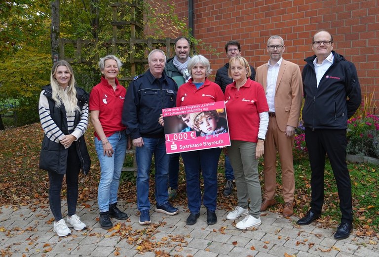 eine Gruppe von Frauen und Maennern mit einem Scheck 