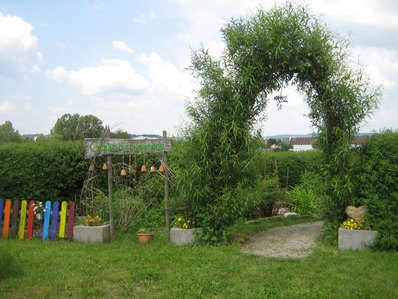 Eingang zu einem Garten mit einem begruenten Eingangstor