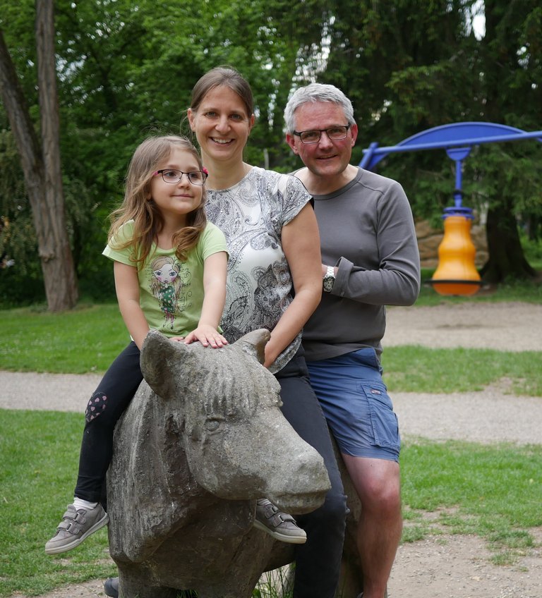 Familie sitzt auf einem Pferd aus Stein  