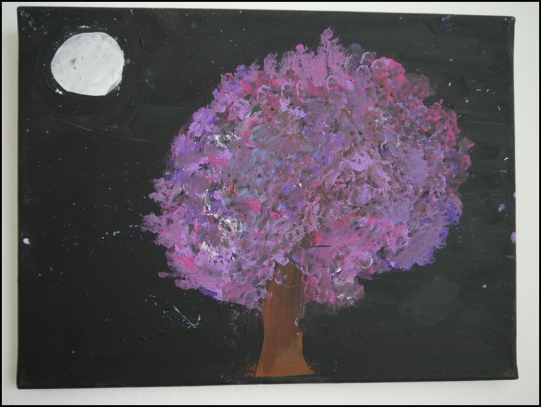 Baum mit lila-pinkfarbenem Blaetterwerk vor schwarzem Hintergrund, links oben der Mond