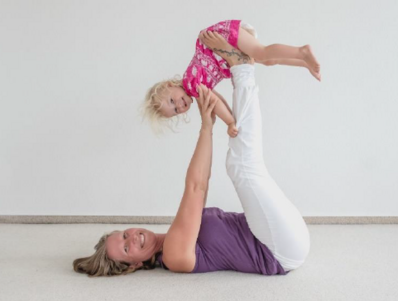 Mutter macht Yogaübungen mit einem Kleinkind 