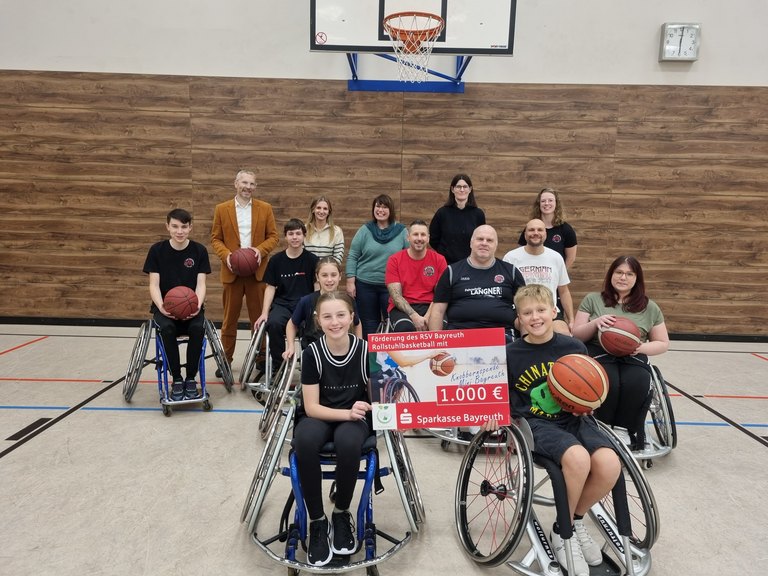 Gruppe von Kinder und Jugendlichen mit einem Scheck