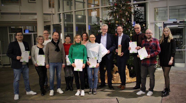 mehrere Personen mit einer Urkunde in der Hand 