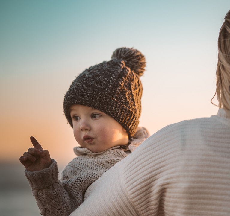Kleiner Junge auf dem Arm seiner Mutter 