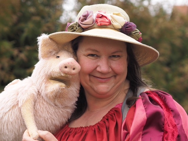 Frau mit einem rosa Plueschschwein