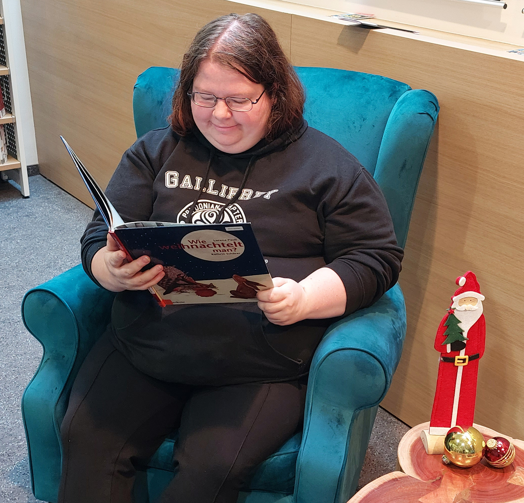 Frau in einem Sessel mit einem Buch in der Hand